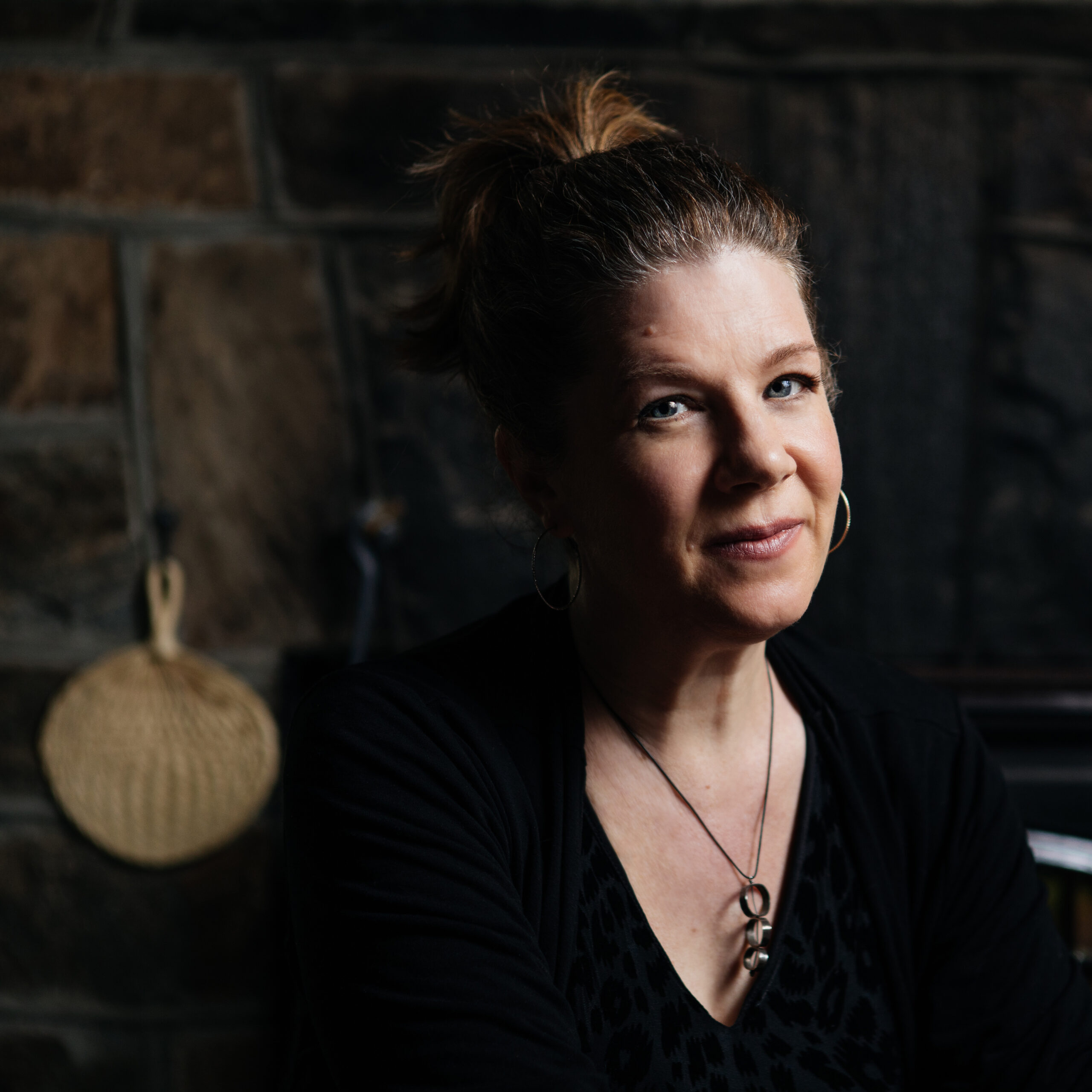 Dar Williams sitting at a table smiling and wearing a black shirt